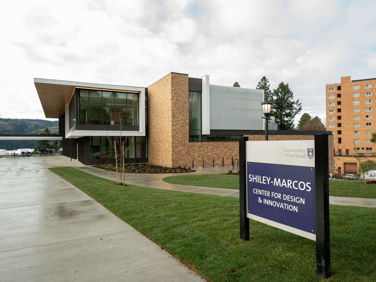 An exterior image of the Shiley Marcos Center with the campus signage in the foreground