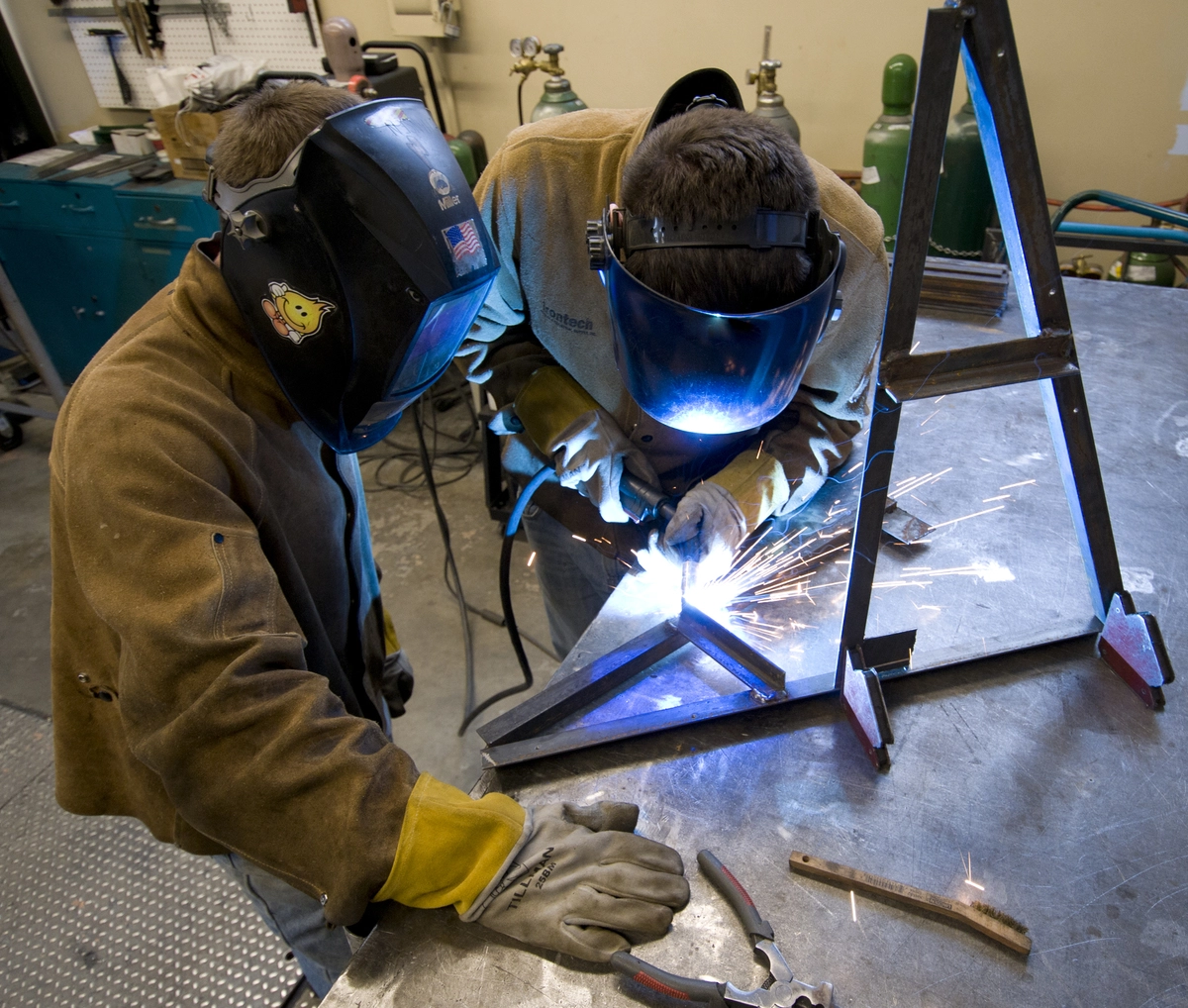 Engineering students weld parts for a project.