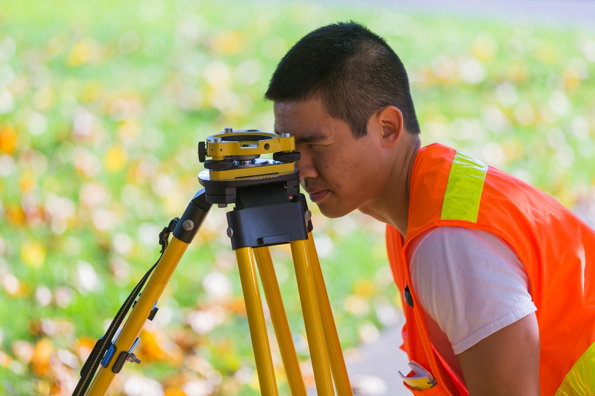 An engineering student using surveying equipment